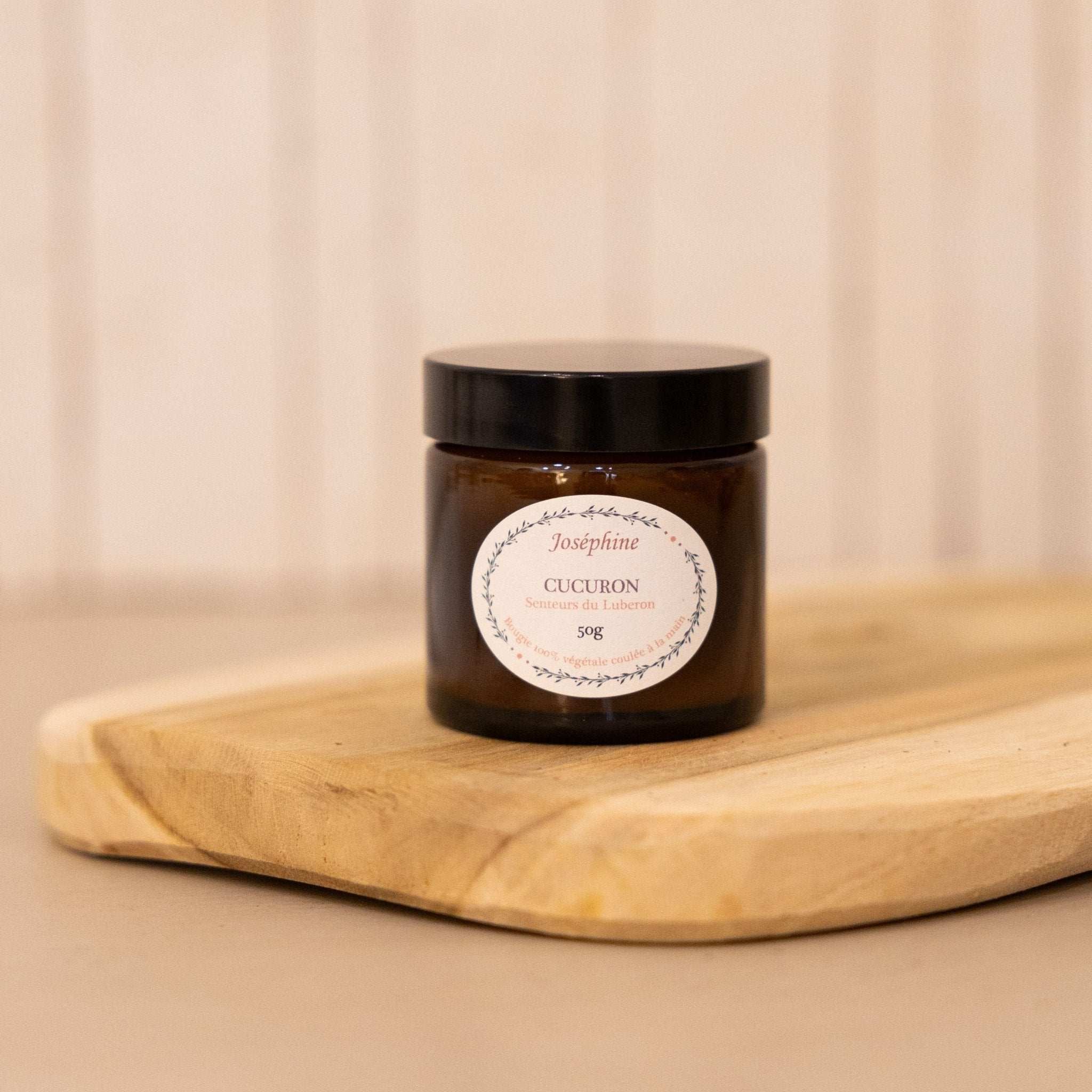A handmade Almond and Verbena scented candle inspired by the village of Cucuron in Provence, with a warm glow in a home setting