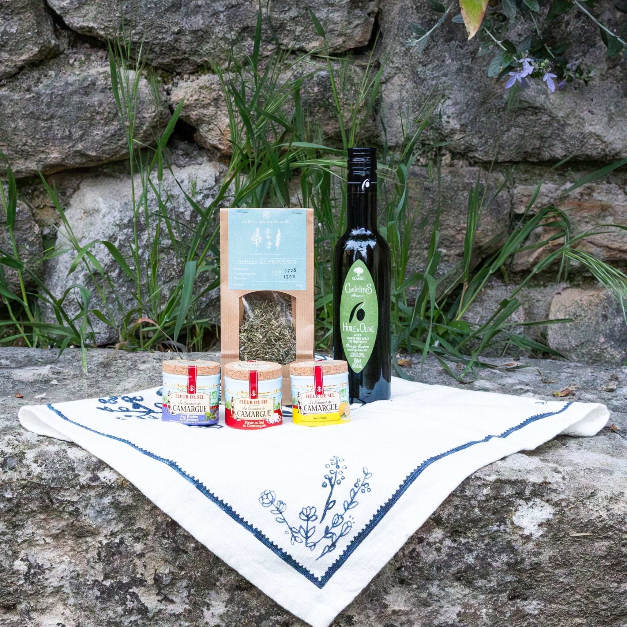 The Condiment Essentials box from Céline en Provence, containing a bottle of olive oil, a jar of Provence herbs, and three pots of Fleur de Sel.