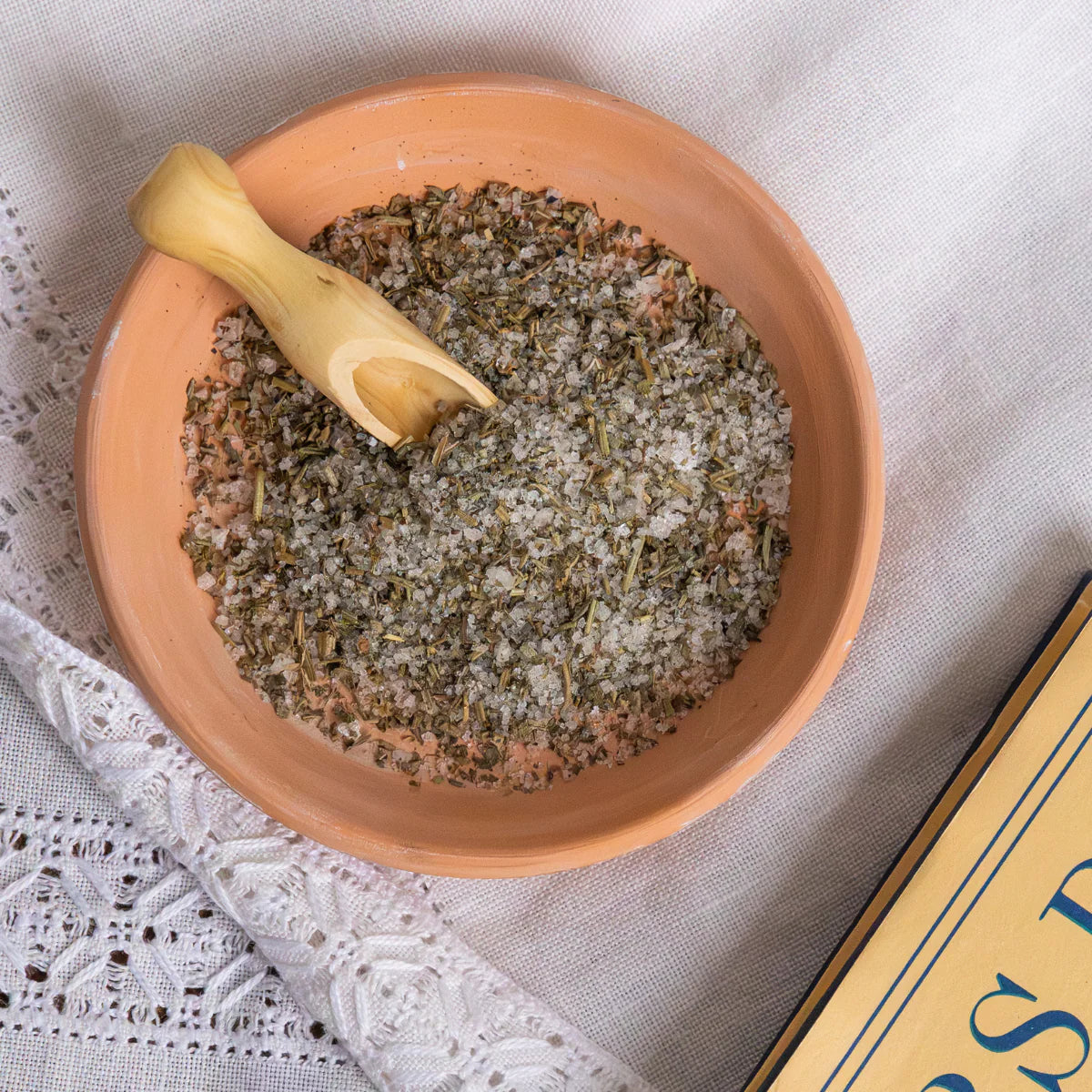 Artisanal wooden salt spoon in a terracotta bowl with Fleur de Sel and Provence herbs, Provençal kitchen accessory