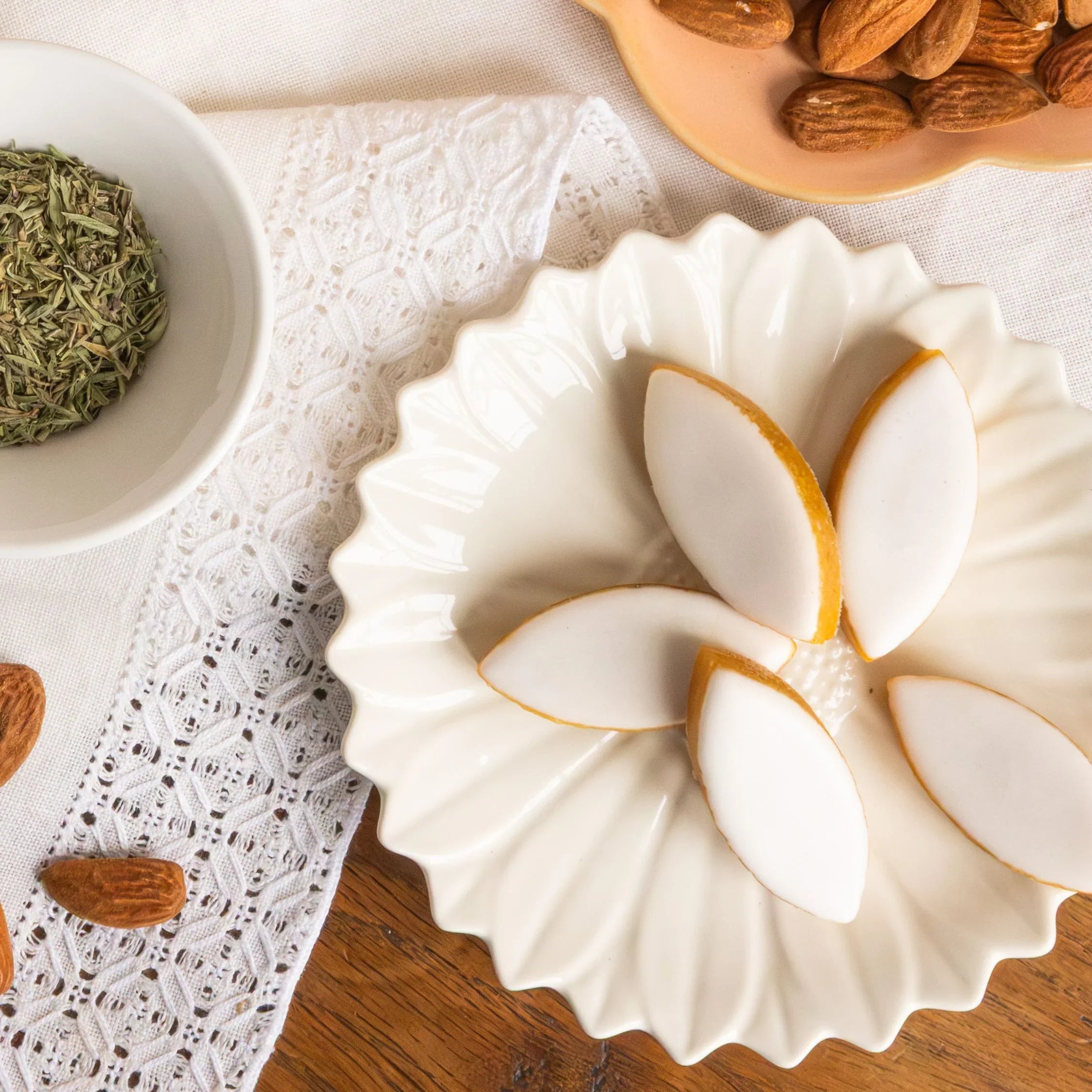 An elegant gold and white box of authentic Calissons d'Aix-en-Provence, featuring the iconic diamond-shaped confectionery on a classic patterned fabric, by Céline en Provence.