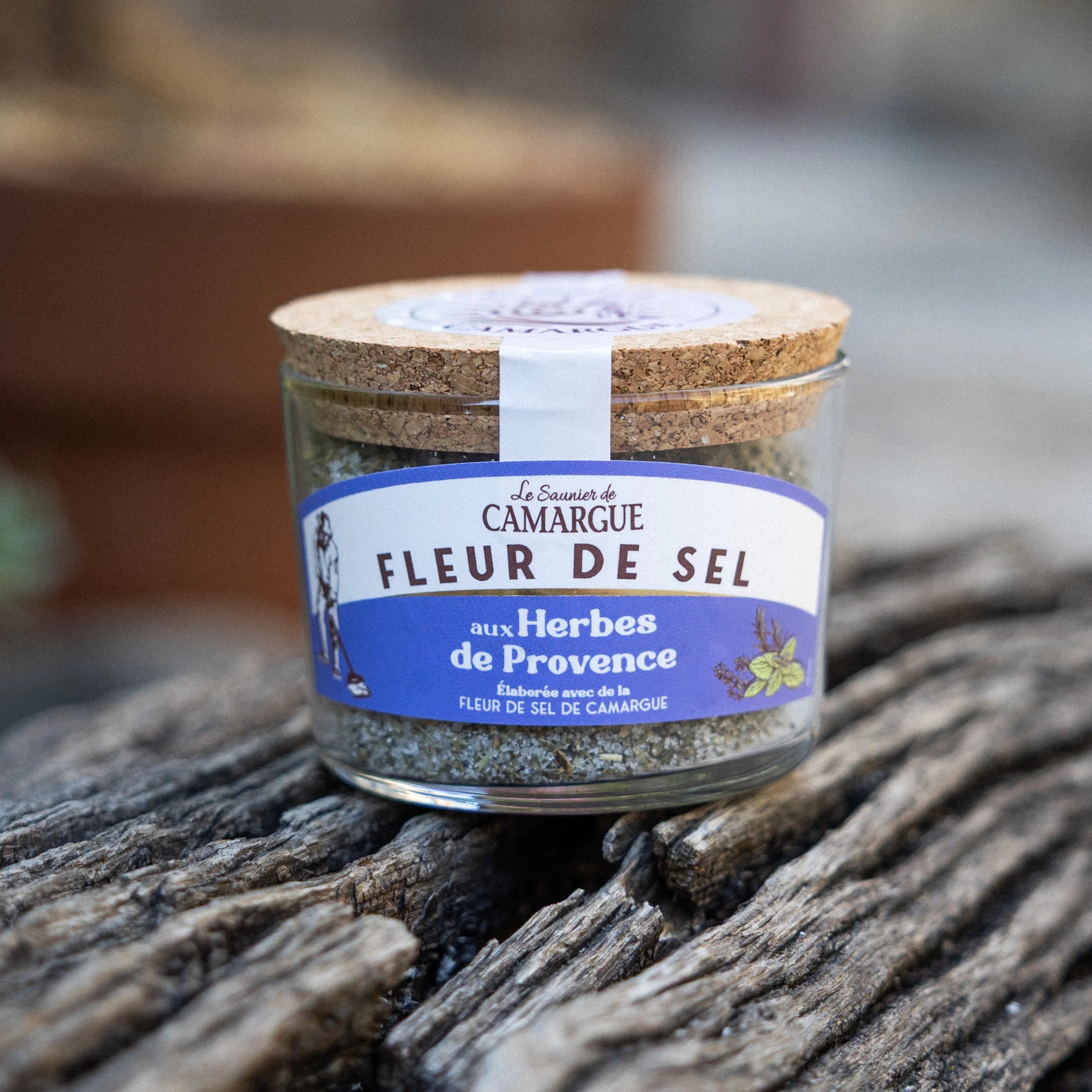Le Saunier de Camargue Fleur de Sel with Provence herbs, glass jar with cork lid on wood