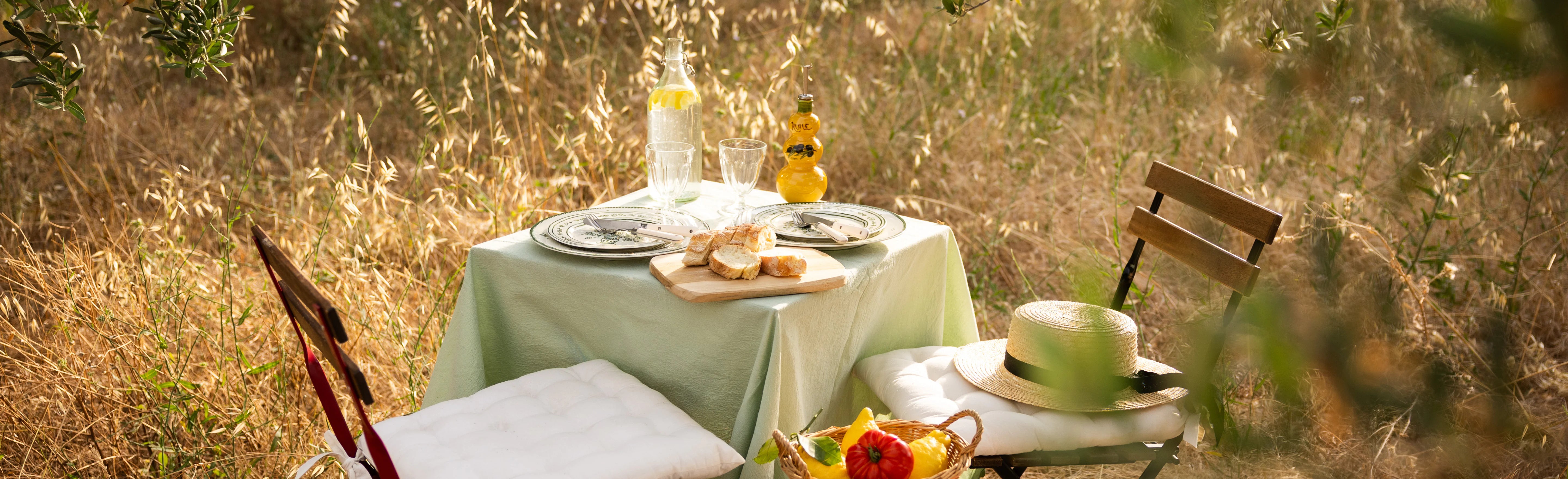 Summer Collection banner, Provençal table set outdoors under olive trees with olive oil and seasonal produce, summer in Provence