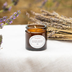 Joséphine lavender scented soy wax candle 50g in amber glass jar on linen surface with dried lavender bunch and blurred lavender field, Provence