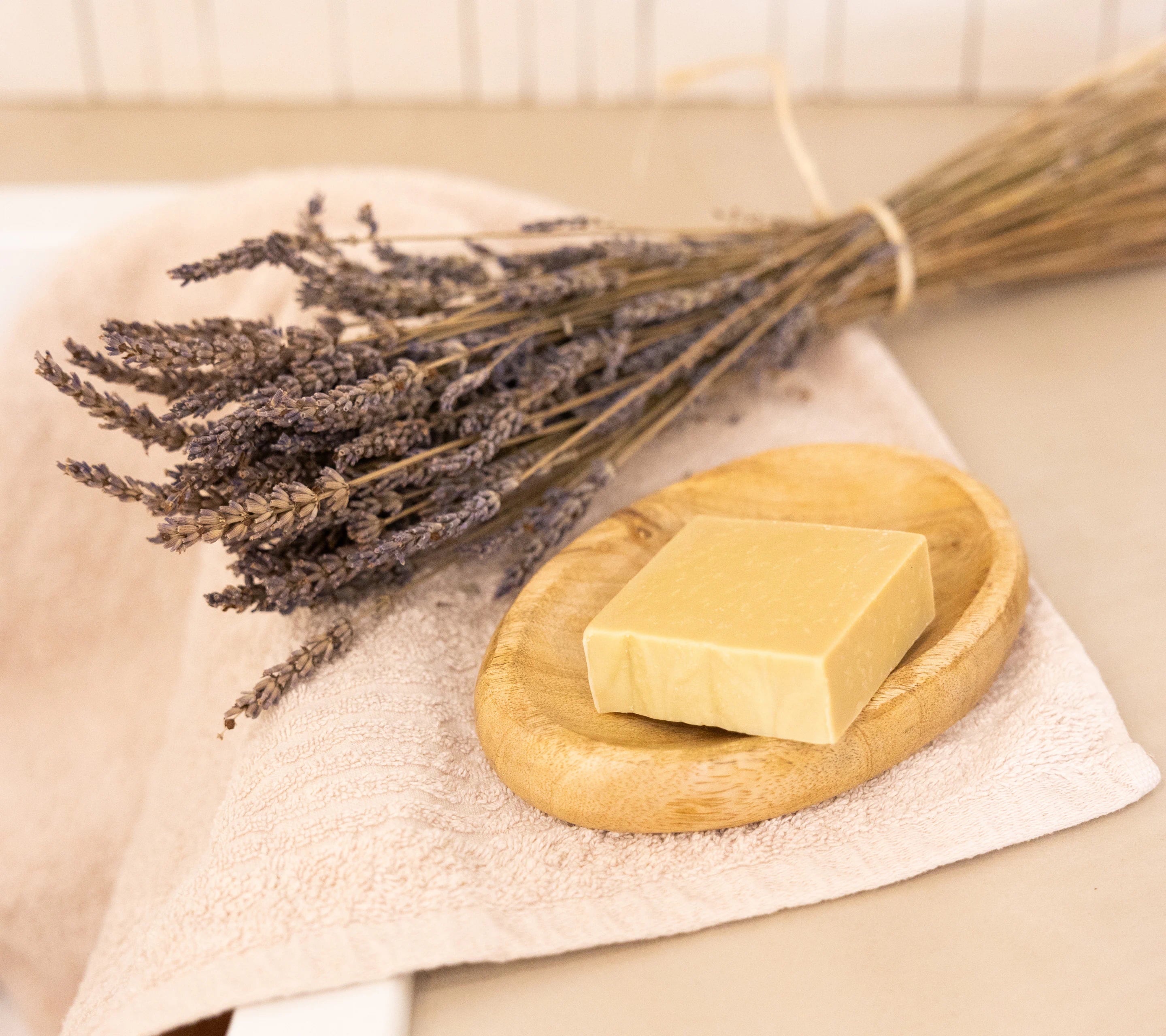 Natural lavender soap paired with dried lavender and a soft towel for a calming Provençal ritual
