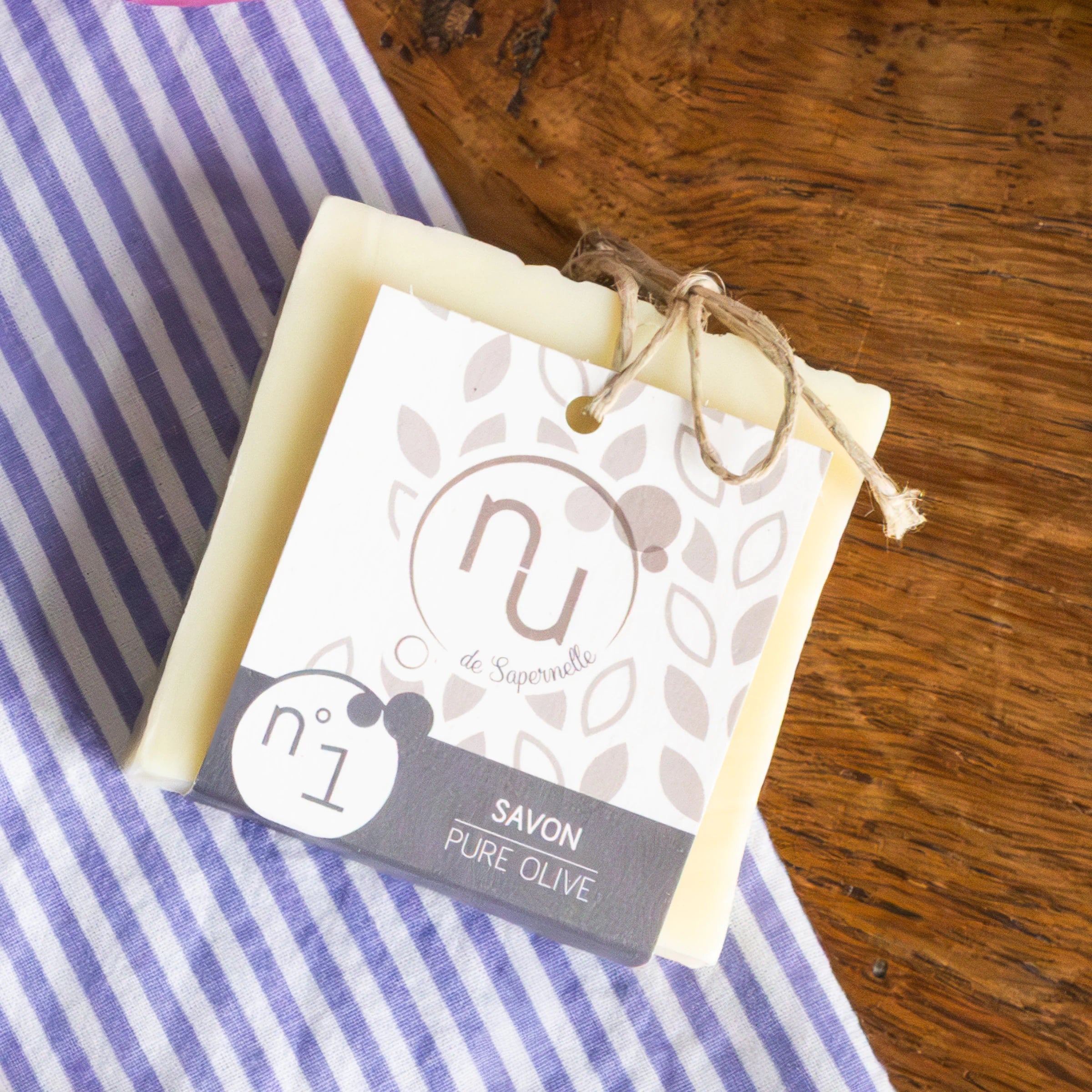 Nu de Sapernelle N°1 pure olive soap bar on wood with Provençal striped fabric