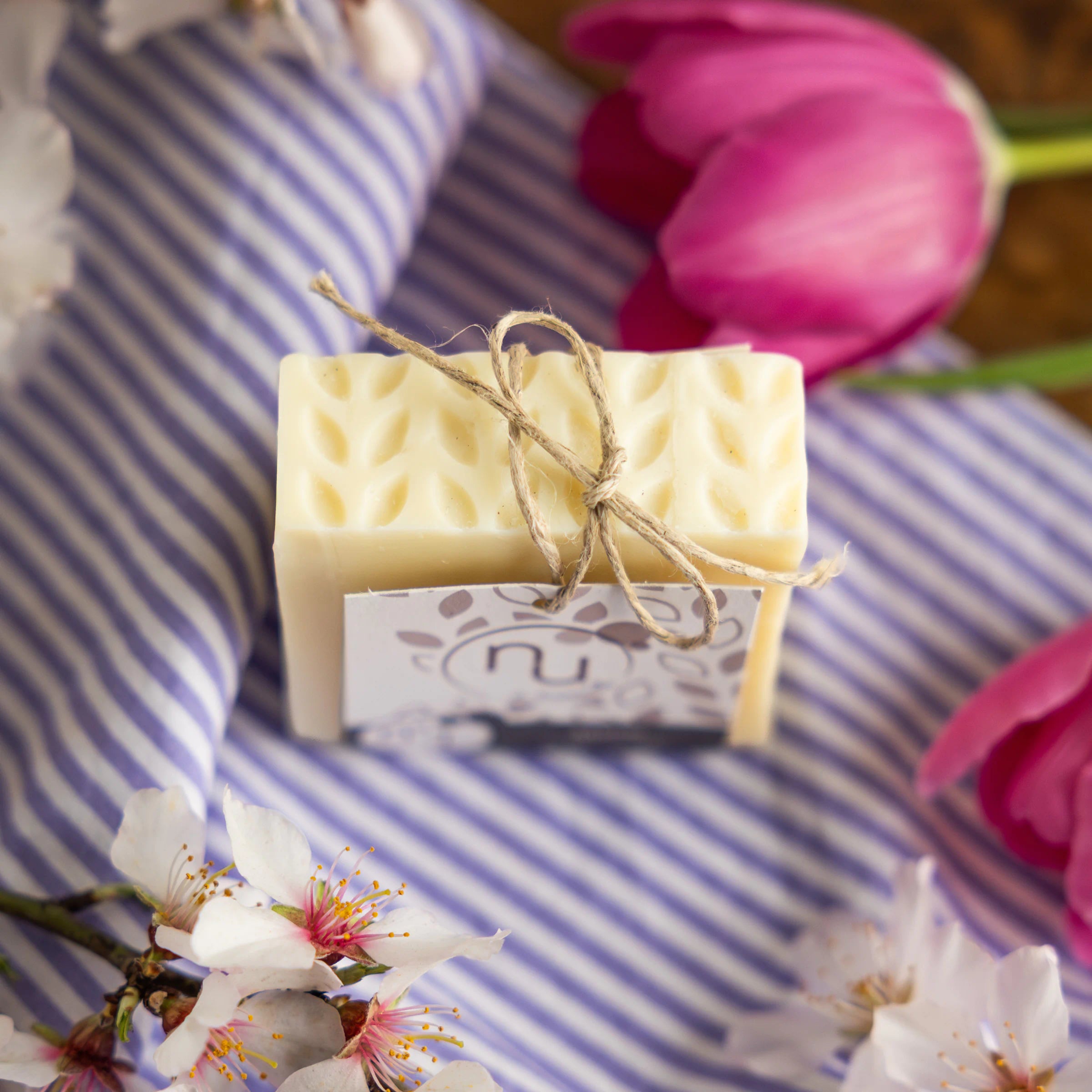 Nu de Sapernelle pure olive soap bar tied with twine, with almond blossom and tulips, Provence