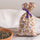 Organic lavender fabric pouch in floral patterned cotton with purple satin ribbon, next to a terracotta bowl of dried lavender seeds, Provence