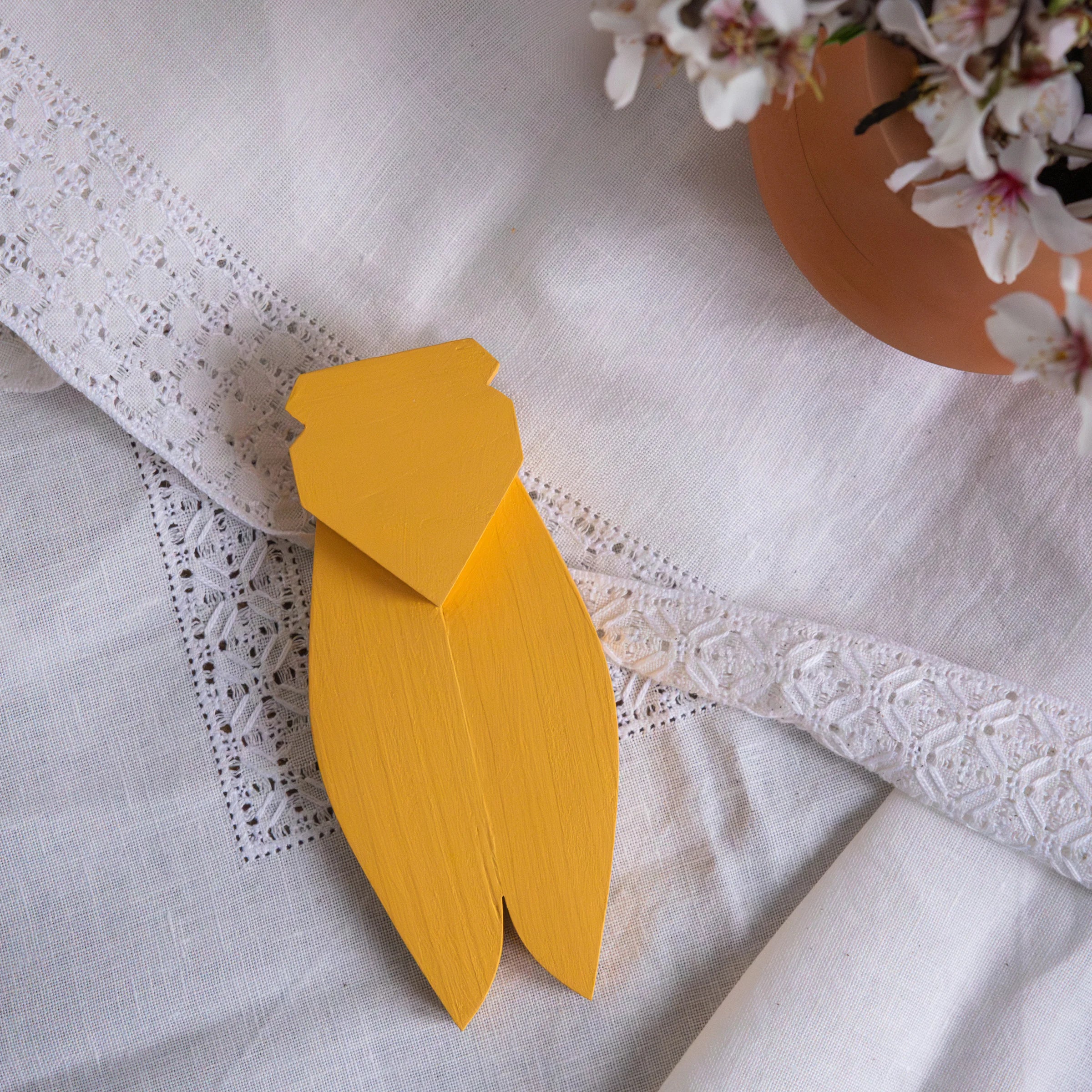 The Spirit of Provence collection with yellow AnimOC decorative wooden cicada on white embroidered fabric with cherry blossom, artisanal Provençal decoration
