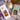 Spring Flavours gift box flat lay with almond croquants, organic lavender honey and Provence herbs on Provençal striped fabric with cherry blossom and tulips