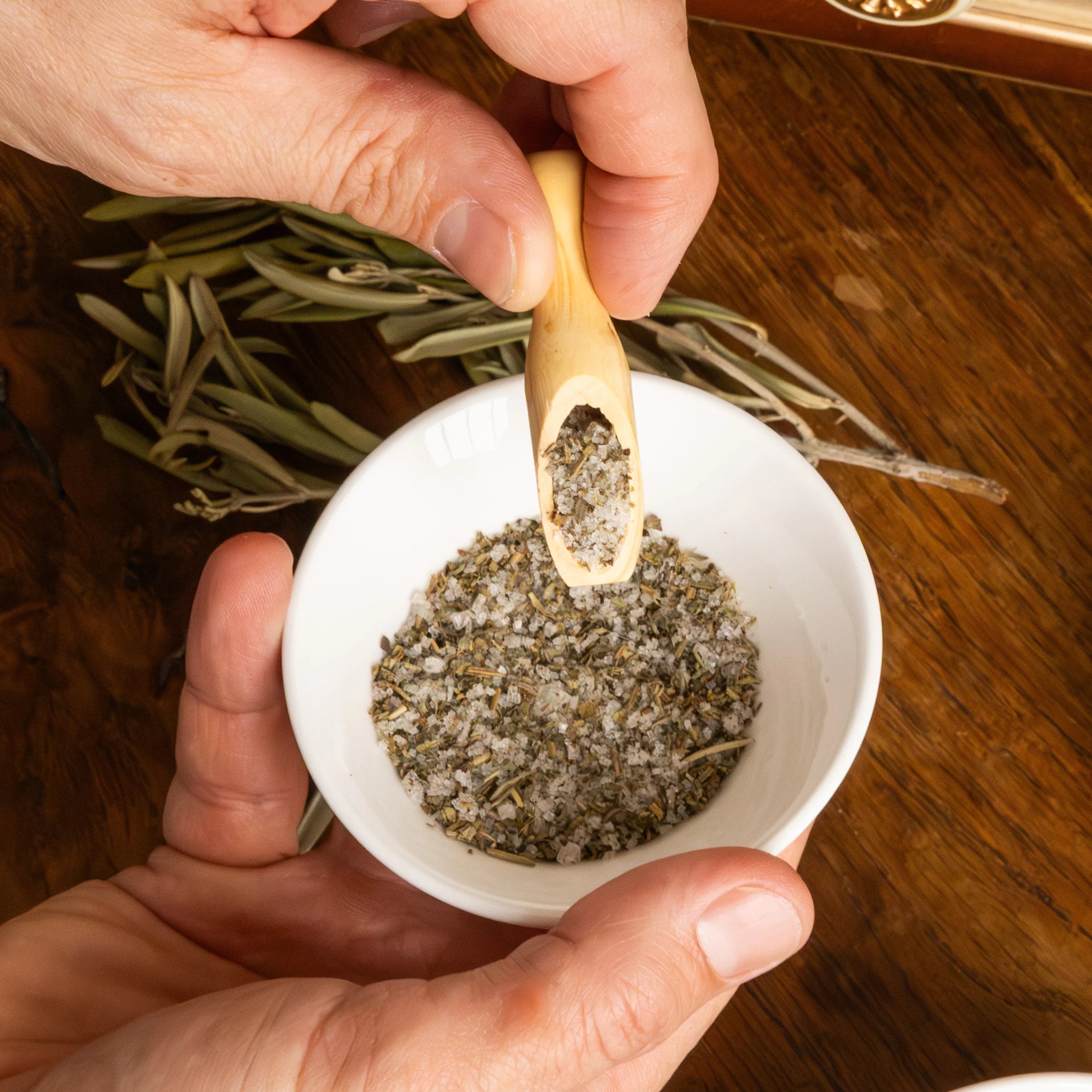 Artisanal wooden salt spoon in a terracotta bowl with Fleur de Sel and Provence herbs, Provençal kitchen accessory